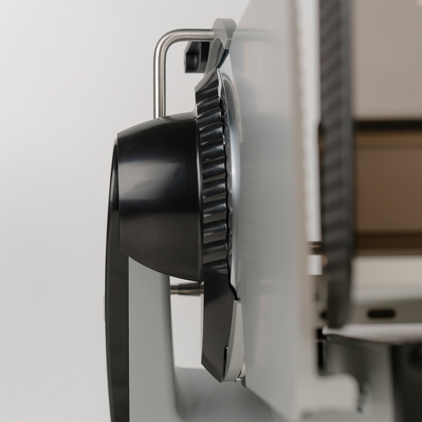 Primo piano di un'affettatrice nera e argento, ripresa dettagliata della lama