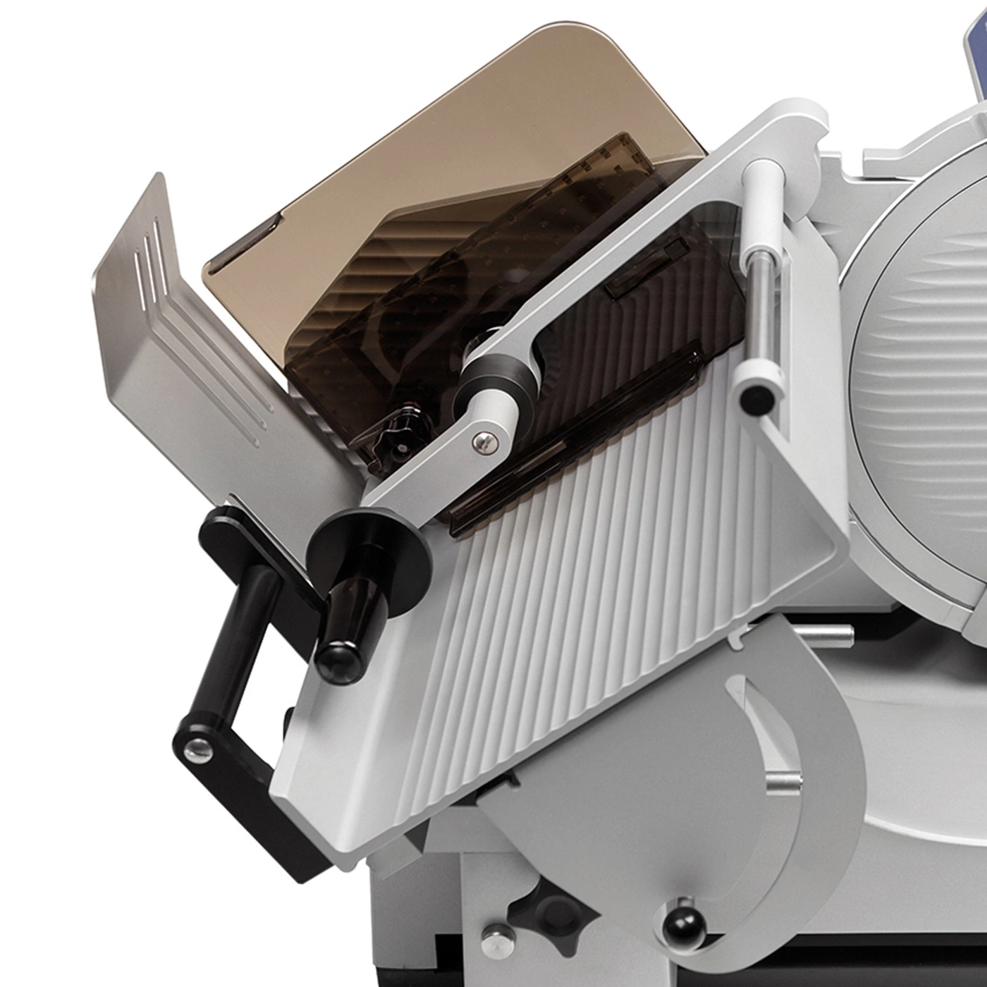 Close-up of a silver meat slicer with protective guards and handles, angled view