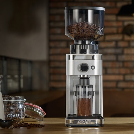 Moulin à café avec grains et café moulu sur une table en bois