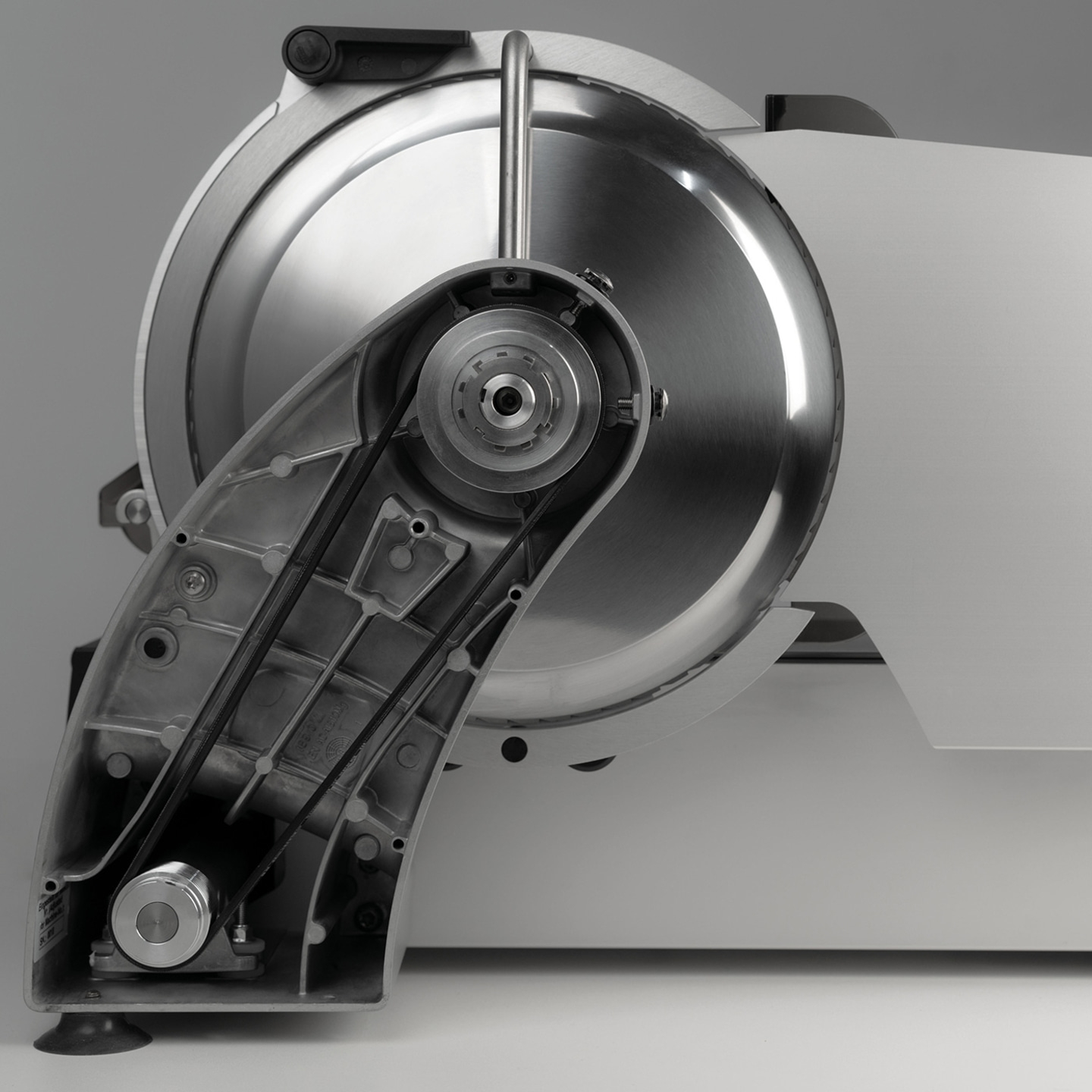 Close-up of a meat slicer with a sharp blade and intricate mechanism.