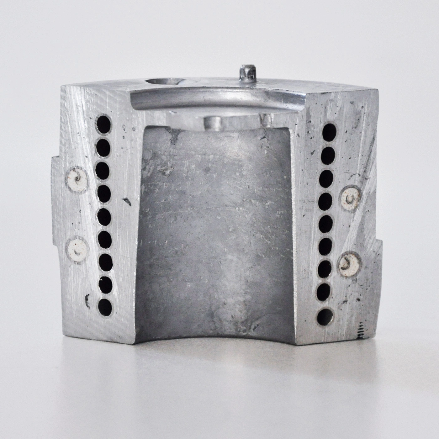 Metal block with holes and a hole in the middle, gray color