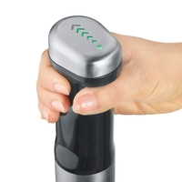 Hand holding stick blender with green lights and arrows