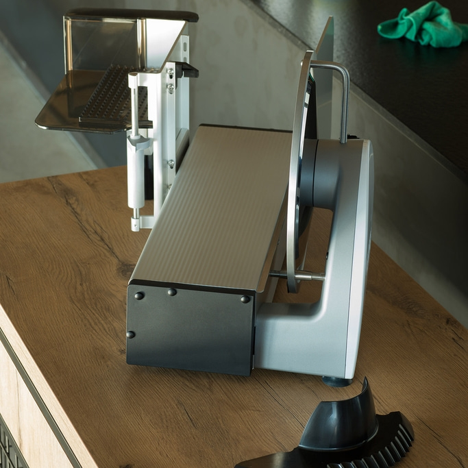 Meat slicer on wooden table, detail shot, kitchen appliance, close-up